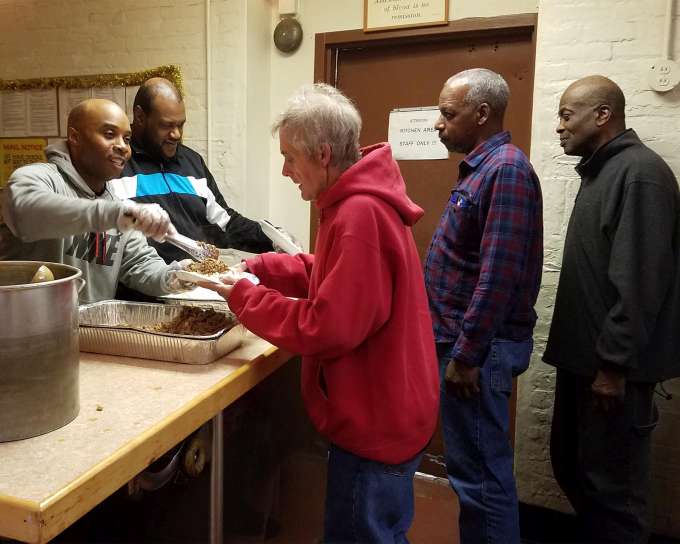 Preacher speakin to group of homeless men